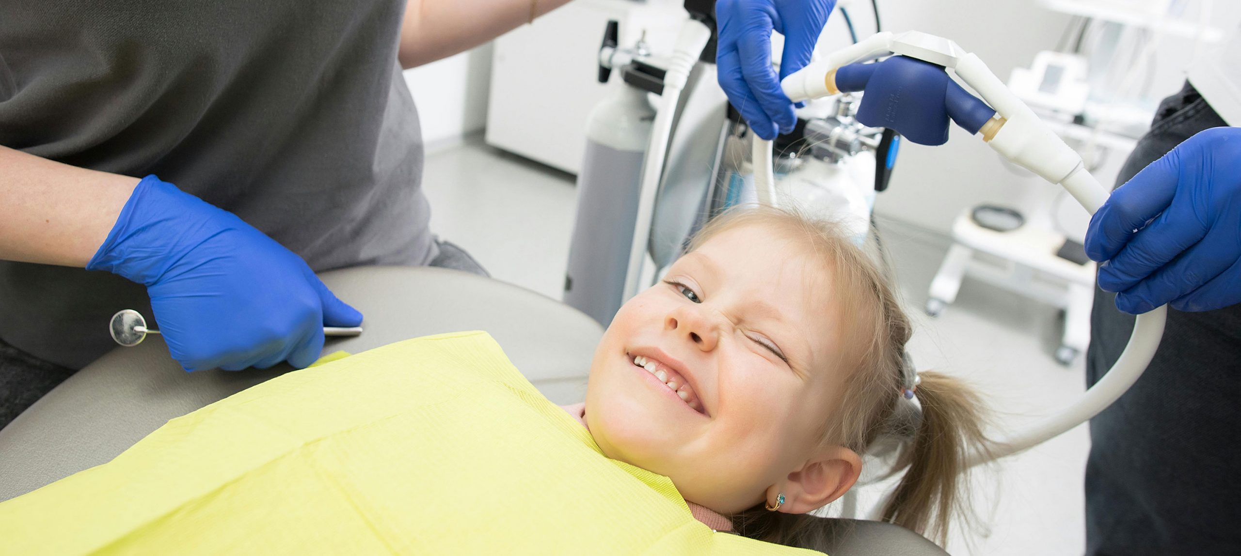 A woman in a dentists chair smiling