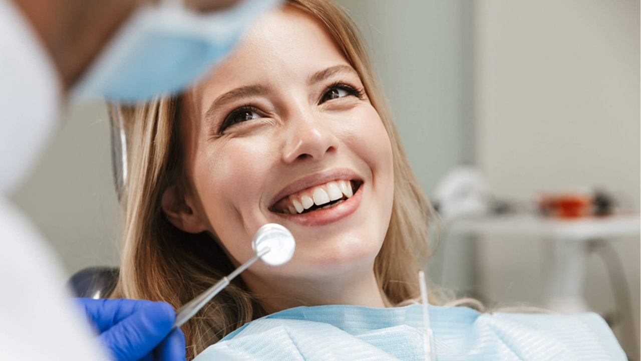 A woman in a dentists chair smiling